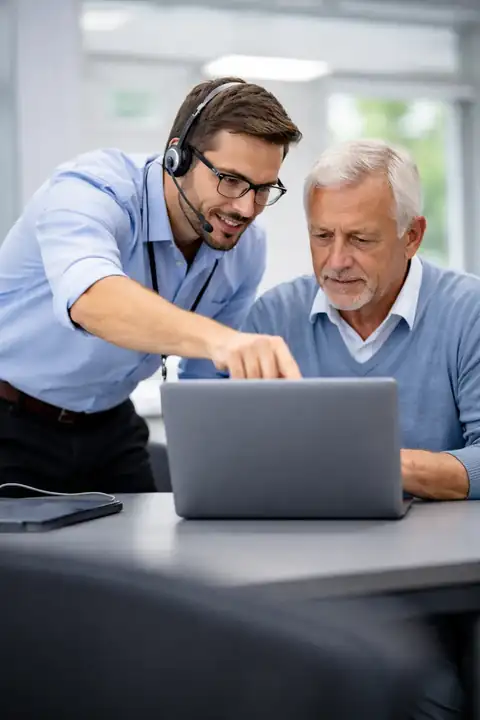 IT consultant helping a business owner review support priorities on a laptop
